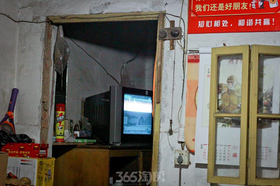 黑白电视正在放映新闻联播,音量开的很大,老板在门外也能听到声音.